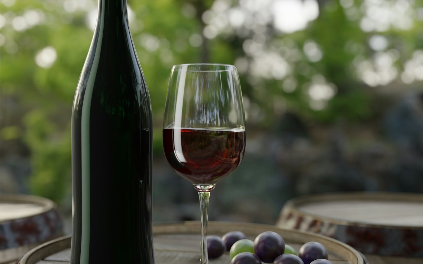 Bouteille de vin et verre posés sur un tonneau, dans les vignes