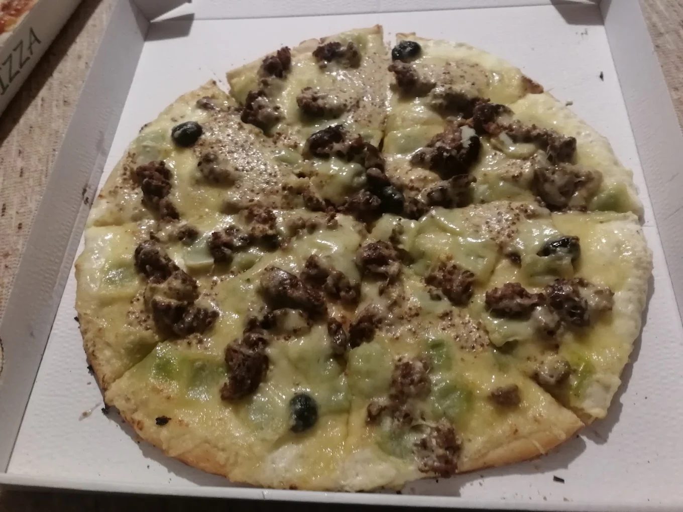 Pizza garnie de viande hachée, préparée à la commande