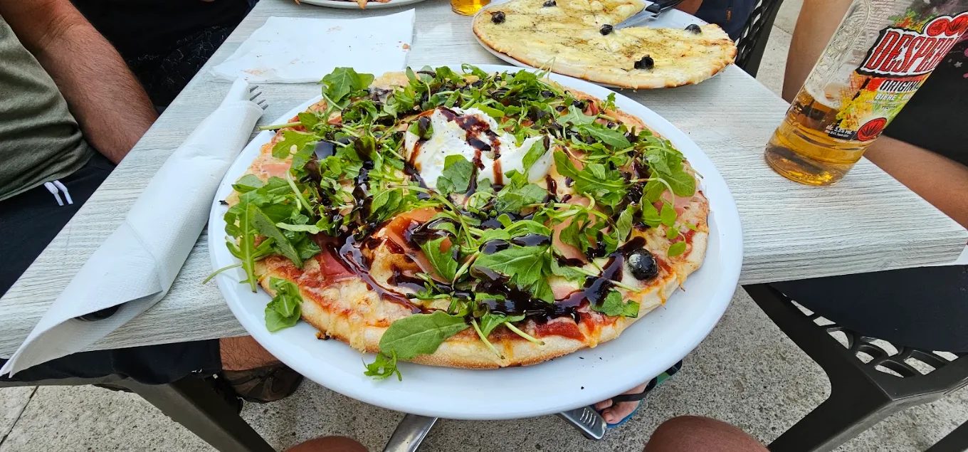 Assiette de salade servie avec une pizza