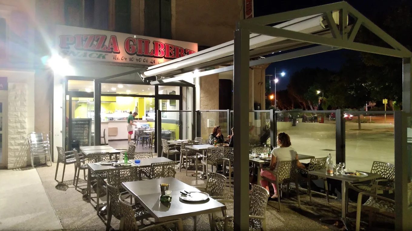 La terrasse éclairée de Pizza Gilbert, le soir, boulevard Victor Hugo à Bollène